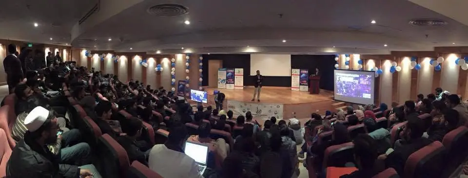Wide view of a full auditorium during a talk
