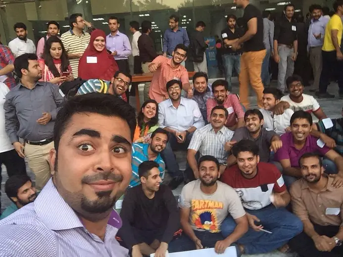 Selfie with a large group seated on the floor at an event