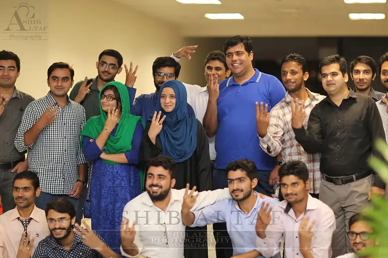 Group of attendees posing with hand signs