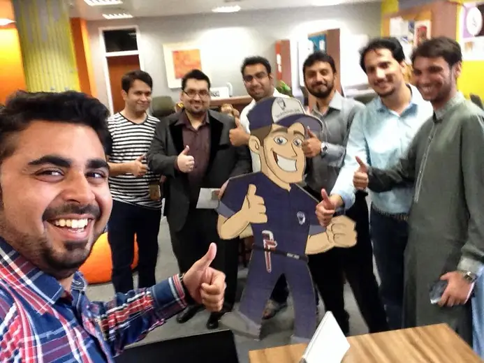 Selfie with a group giving thumbs up next to the Technician.pk mascot cut-out