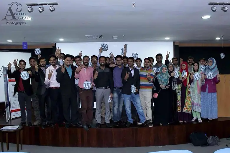 Group on stage holding WordPress logo signs