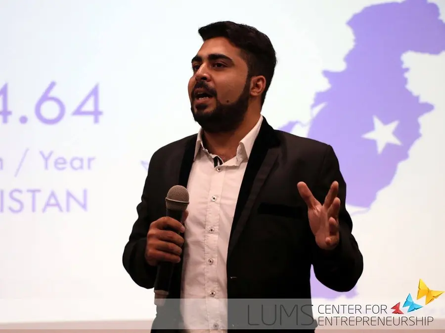 Speaker on stage in front of a slide with a map of Pakistan